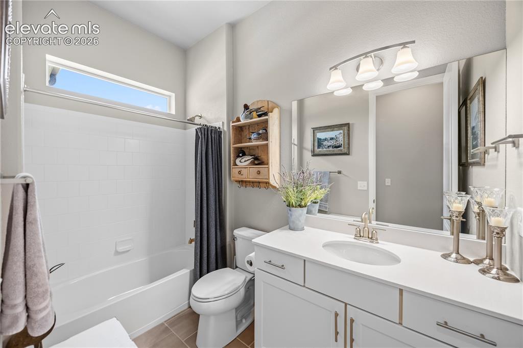 Image 25 of 50: Bathroom featuring a single vanity with an undermount sink, a white counter