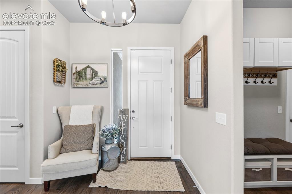 Image 27 of 50: Inviting entry featuring dark wood-finish flooring, a white paneled door, a