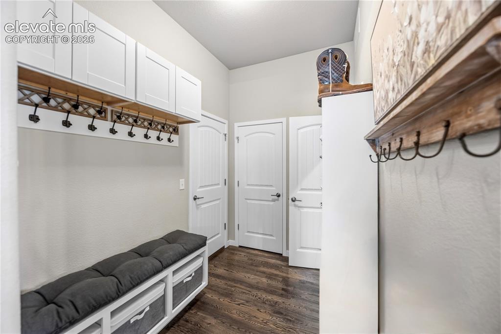 Image 28 of 50: Entryway storage featuring white cabinetry, integrated coat hooks, and buil