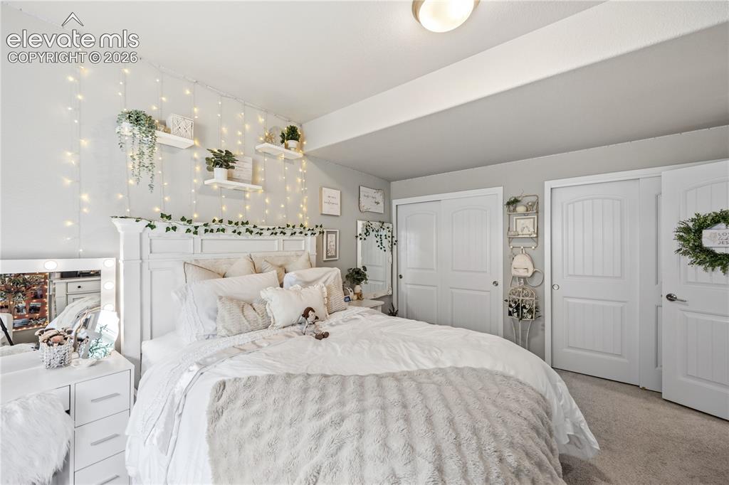 Image 38 of 50: Bedroom featuring neutral wall paint, white trim, and light gray carpeting