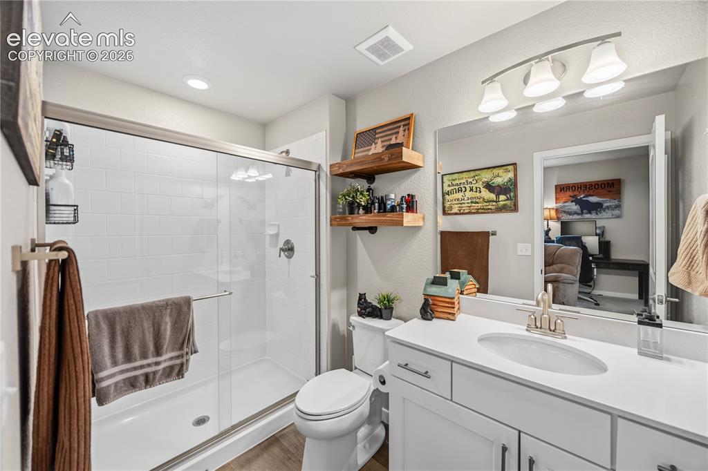 Image 44 of 50: Bathroom featuring a glass-enclosed shower with white subway tile, a single