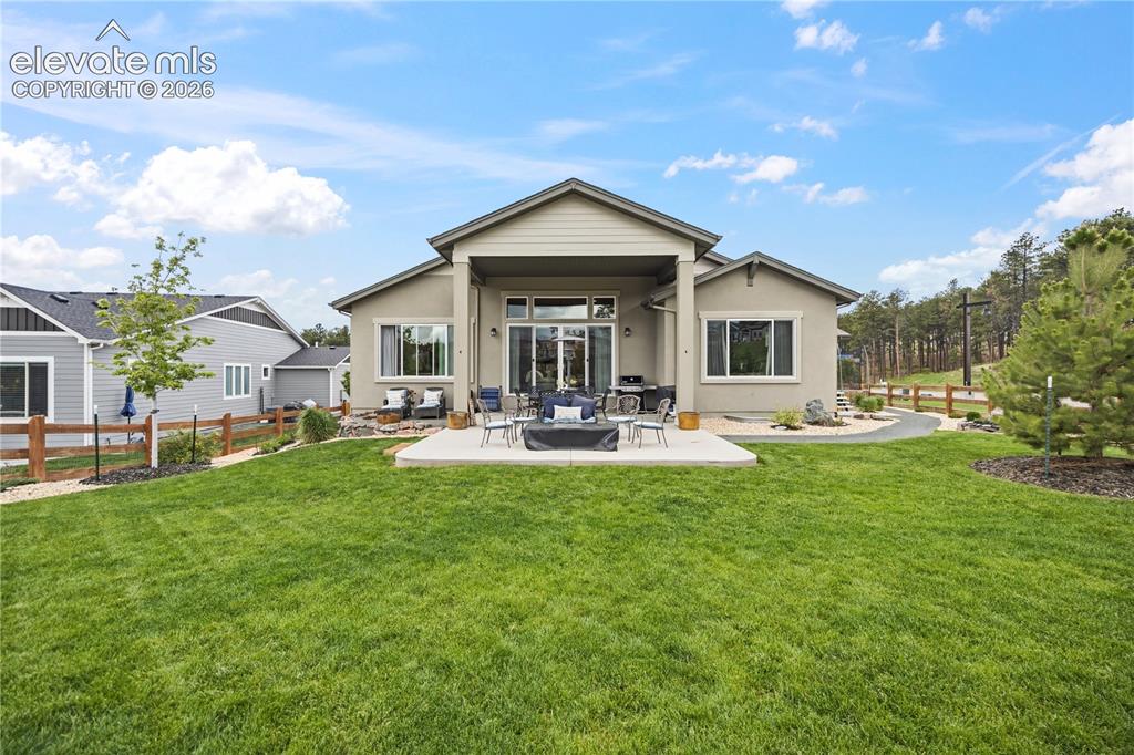 Image 46 of 50: Expansive rear yard featuring a concrete patio, covered outdoor living spac