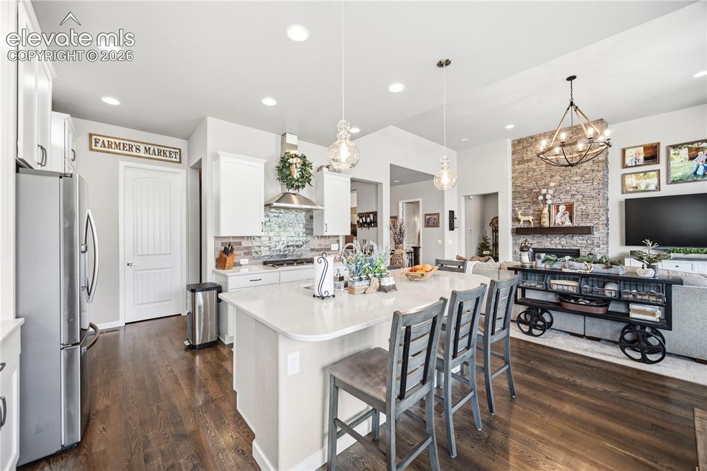 Image 7 of 50: Open-concept kitchen featuring an oversized island with seating, stainless