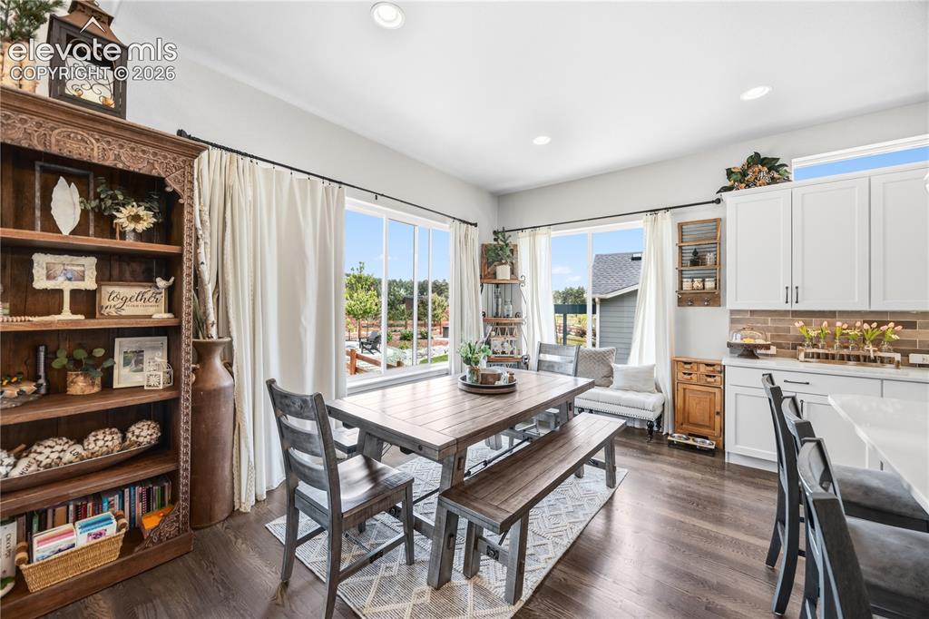 Image 8 of 50: Spacious dining area featuring wood-finish flooring, recessed lighting, and