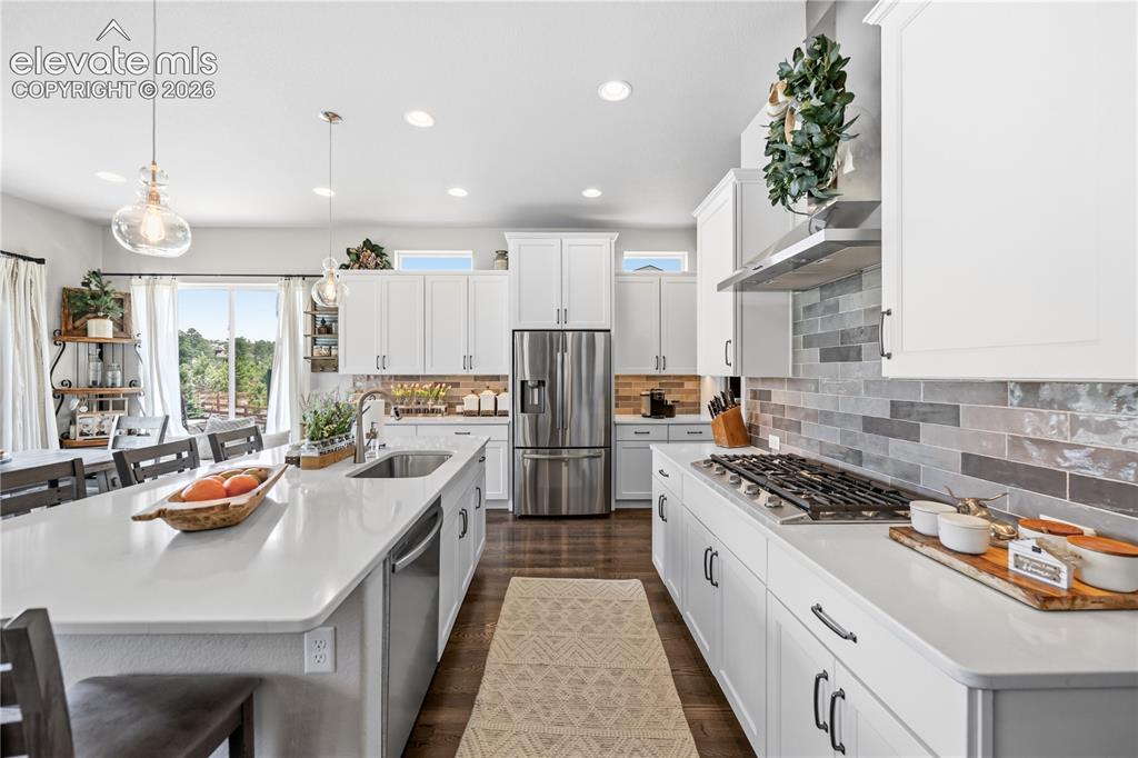 Image 9 of 50: Spacious dining area featuring wood-finish flooring, recessed lighting, and