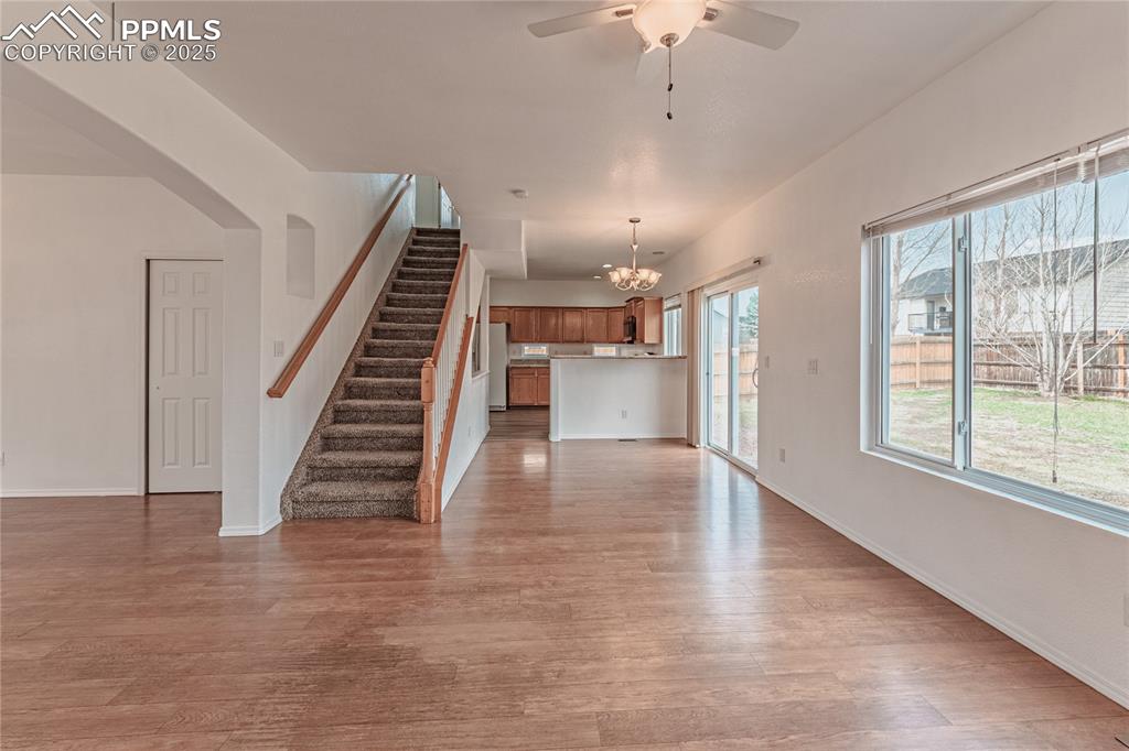Image 17 of 47: Unfurnished living room with baseboards, ceiling fan with notable chandelie
