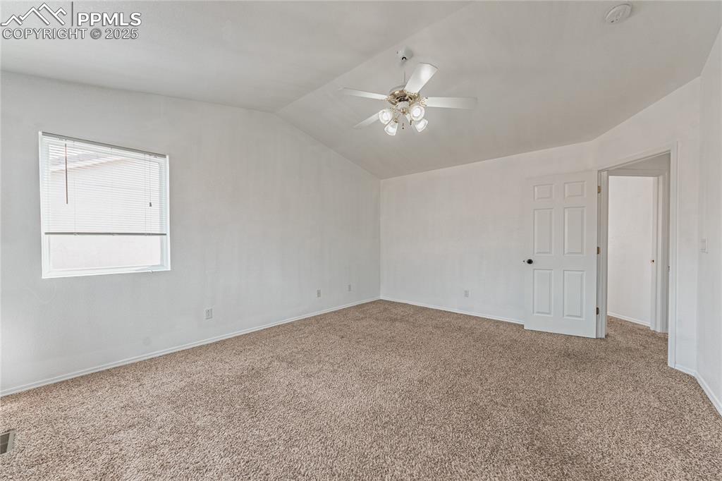 Image 31 of 47: Carpeted spare room with baseboards, lofted ceiling, and a ceiling fan