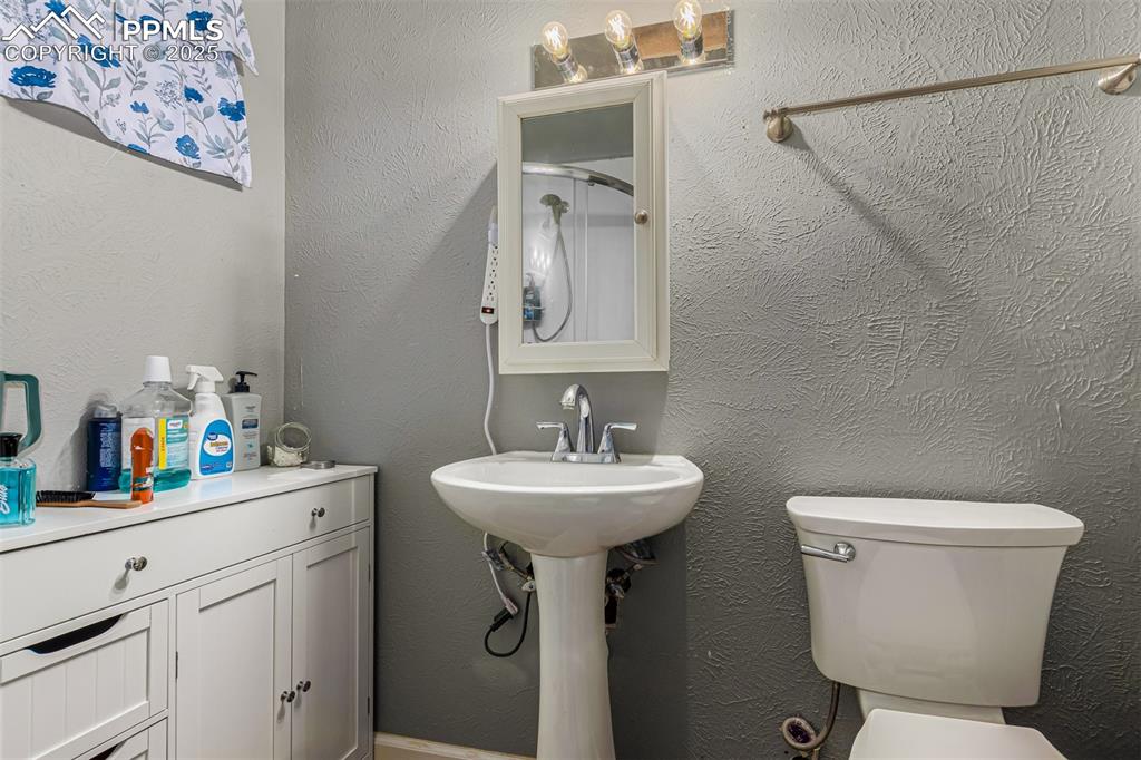 Image 5 of 17: Bathroom with a textured wall and a shower with shower curtain