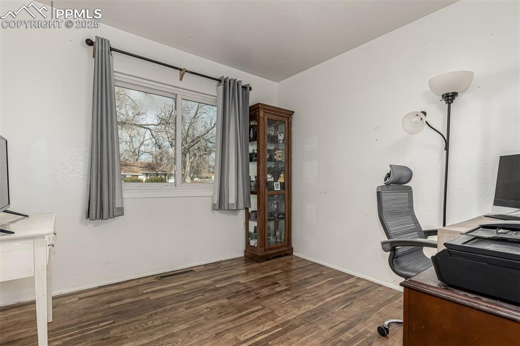 Image 8 of 17: Office space with dark wood finished floors and baseboards