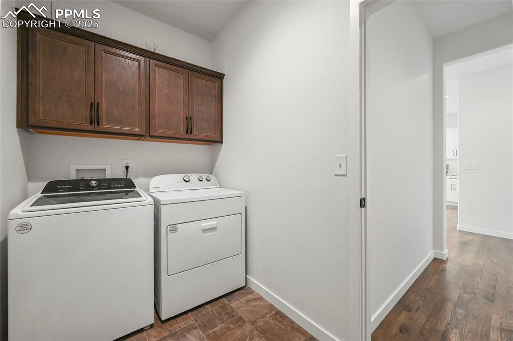 Image 18 of 38: Laundry room featuring independent washer and dryer, cabinet space, and dar