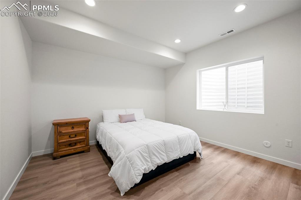 Image 26 of 38: Bedroom with wood finished floors and recessed lighting
