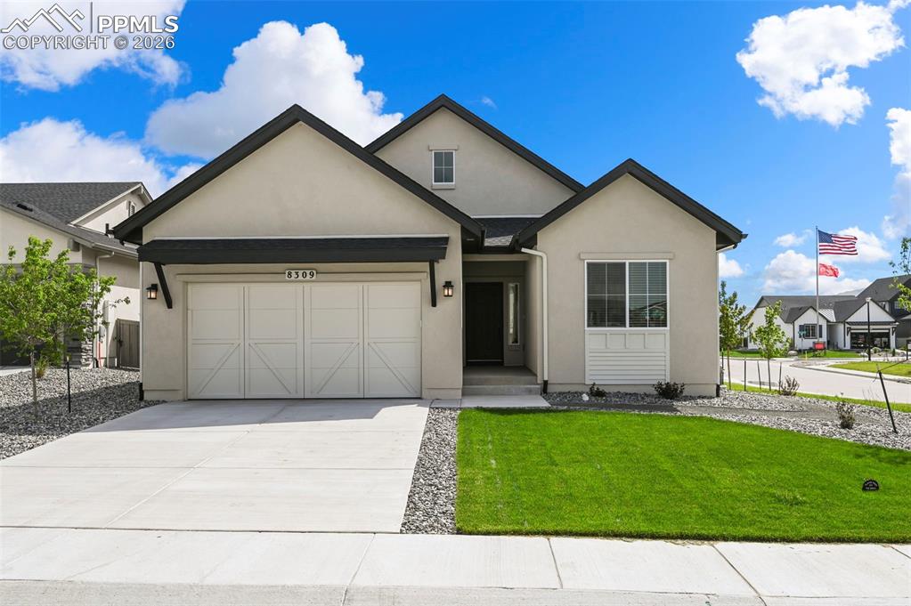Image 3 of 38: View of front of home featuring an attached garage, stucco siding, driveway