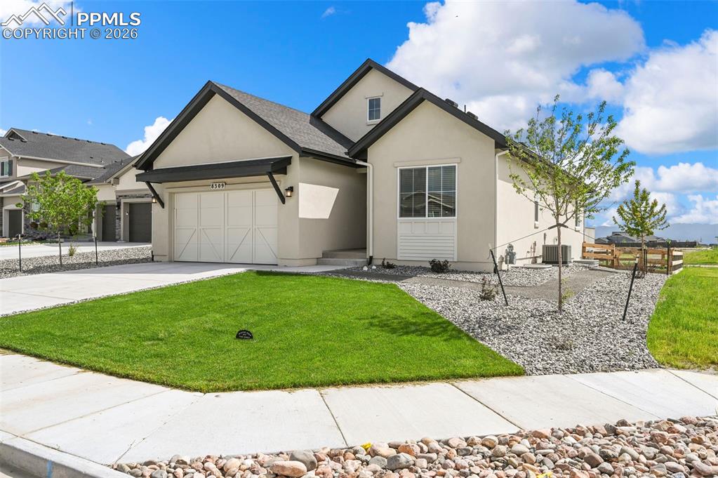 Image 4 of 38: View of front of property featuring a garage, stucco siding, concrete drive