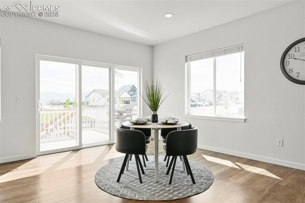 Image 9 of 38: Dining room with wood finished floors and recessed lighting
