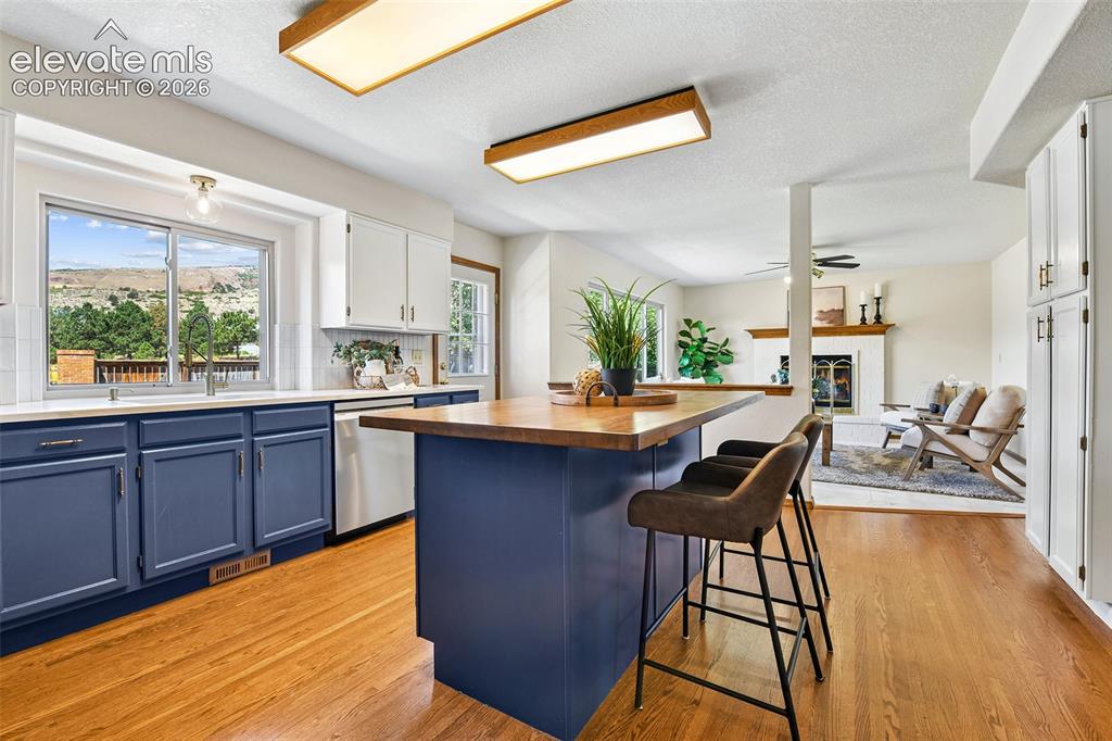 Image 10 of 42: Granite counters and textured subway tile backsplash, as well as center isl