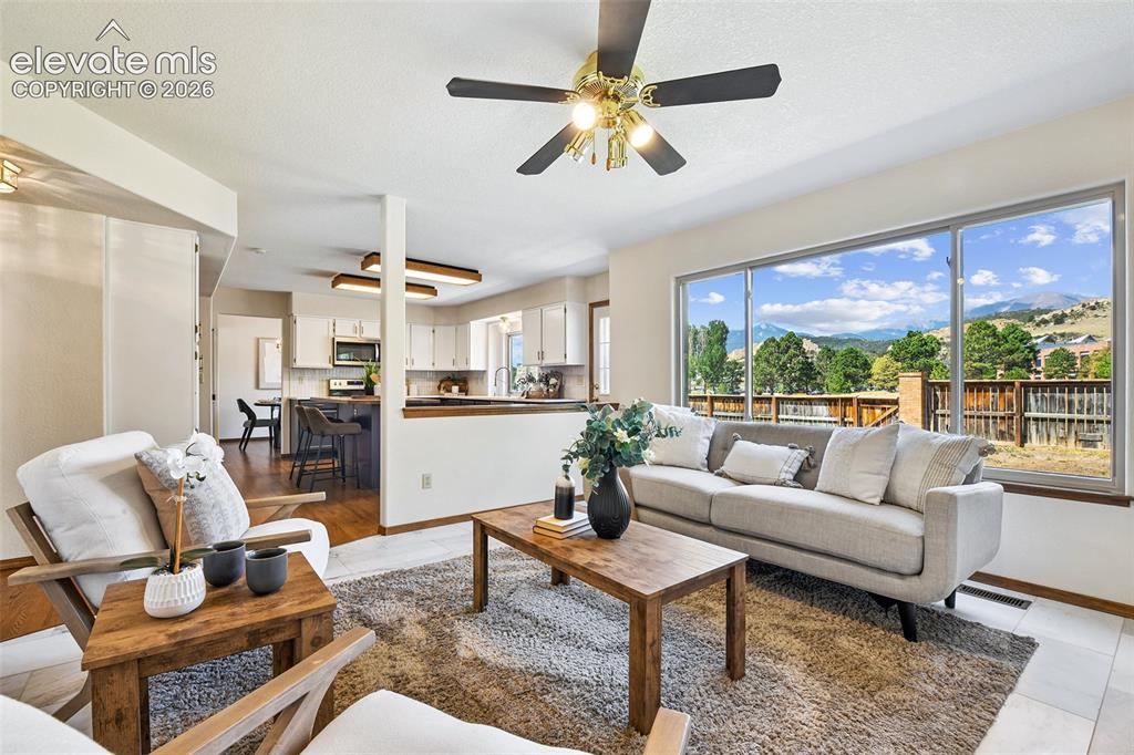 Image 13 of 42: Honed Marble Tile flooring and Brick woodburning fireplace for cozy evening