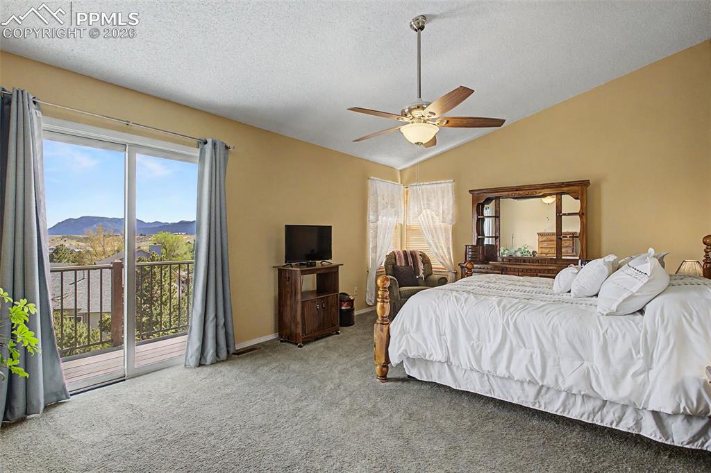 Image 21 of 46: Upper level Primary bedroom, sliding glass door leads to private upper deck