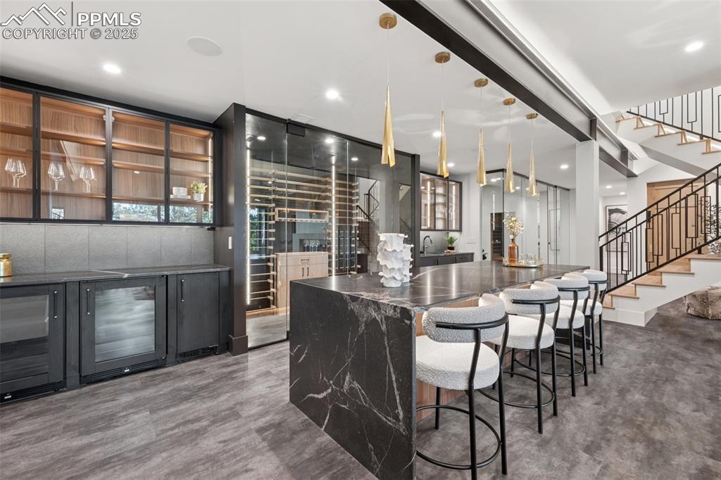 Image 34 of 50: Temp Controlled Wine Room built in bar with island