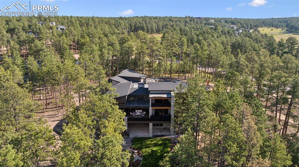 Image 45 of 50: Aerial view of property and surrounding area featuring a forest