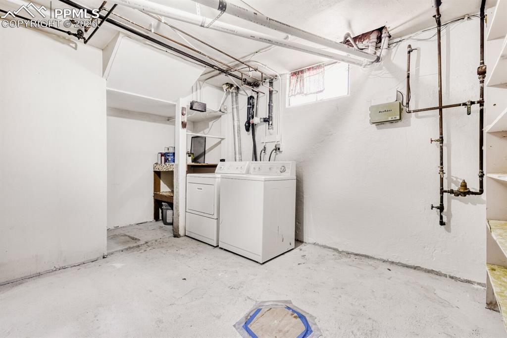 Image 21 of 34: Laundry area with concrete flooring and washing machine and clothes dryer