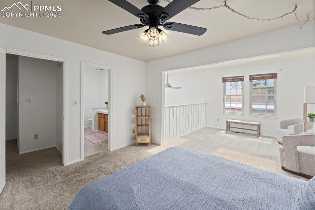 Image 14 of 31: Bedroom featuring light carpet, ceiling fan, and ensuite bathroom