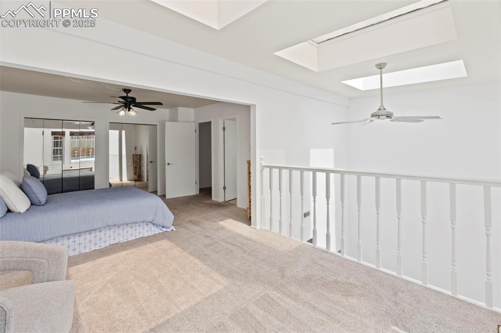 Image 17 of 31: Bedroom featuring carpet flooring, multiple closets, a skylight, and ceilin