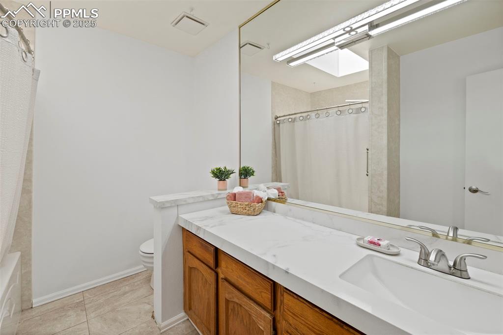 Image 18 of 31: Bathroom with vanity, light tile patterned flooring, and shower / bath comb