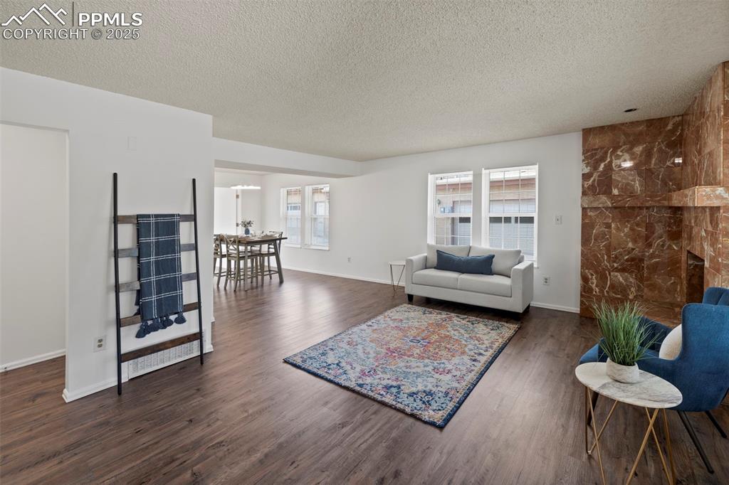 Image 2 of 31: Living area featuring dark wood-type flooring and a textured ceiling