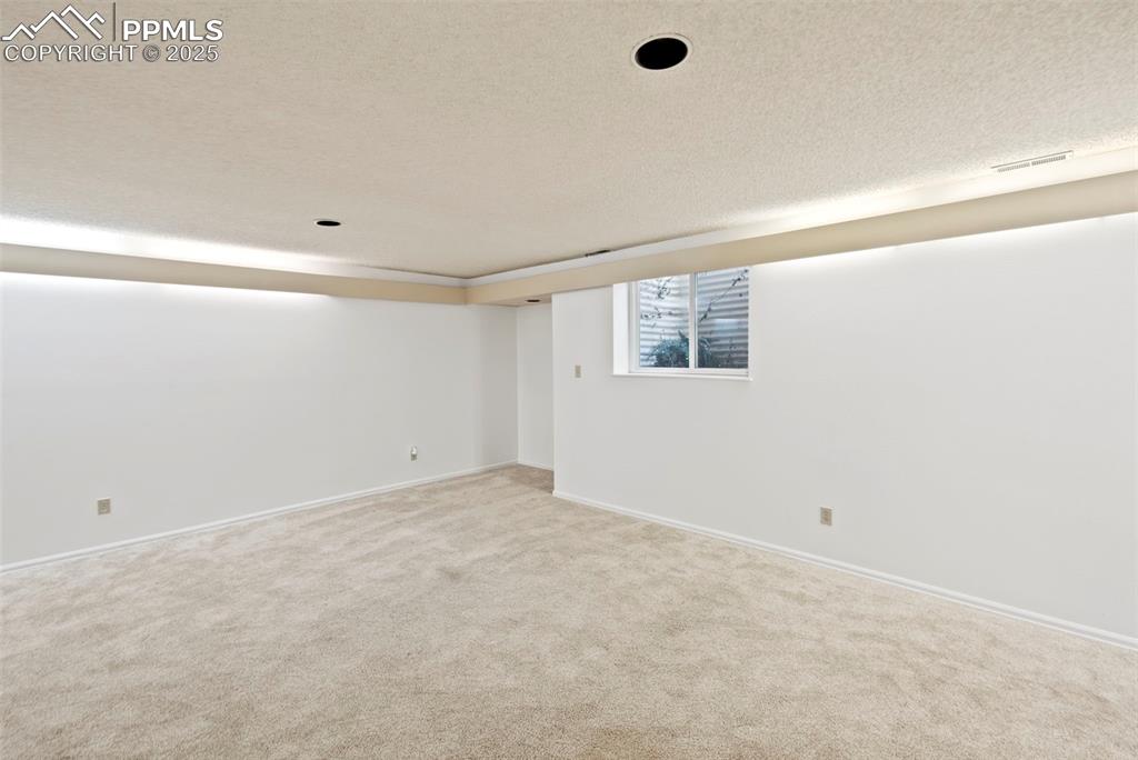 Image 24 of 31: Spare room with a textured ceiling and carpet flooring