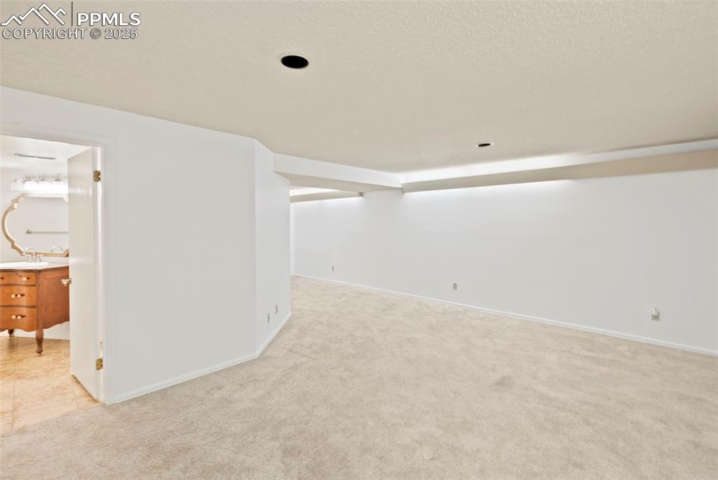 Image 25 of 31: Unfurnished room featuring light carpet and a textured ceiling