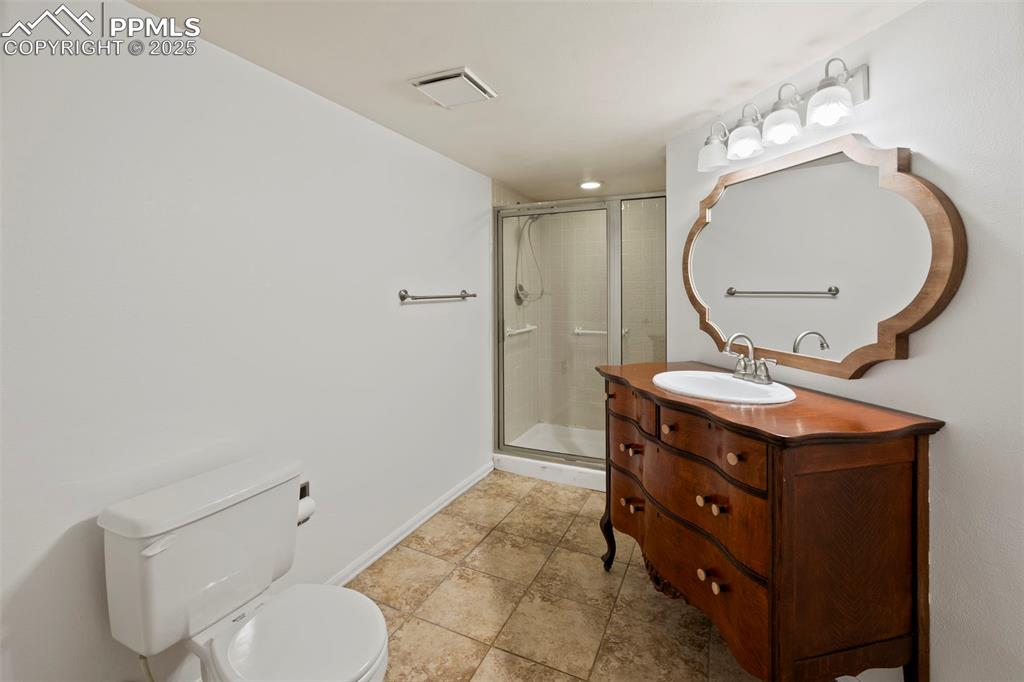 Image 26 of 31: Bathroom with vanity and a stall shower