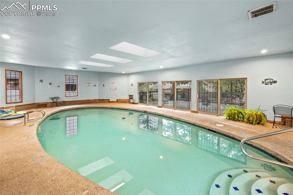 Image 29 of 31: Indoor community pool with a skylight