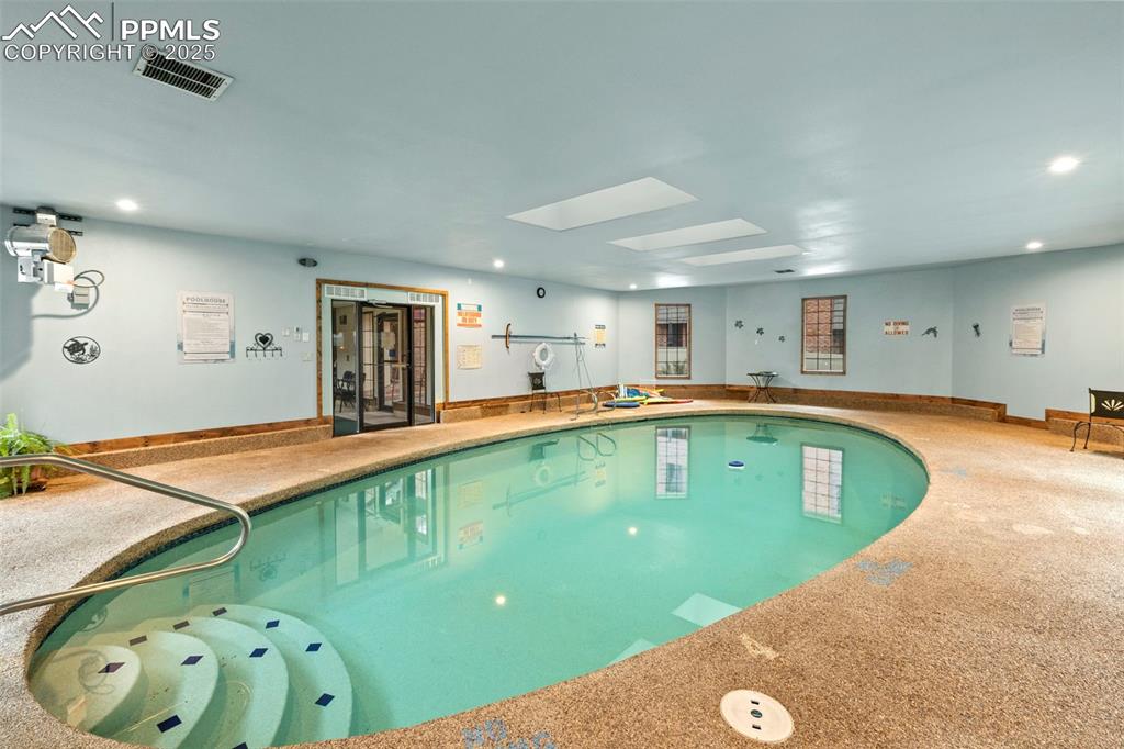 Image 30 of 31: Indoor pool with a skylight