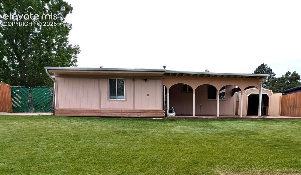 Image 12 of 16: Back of house, large covered patio, landscaped, beautiful grass, double-gat