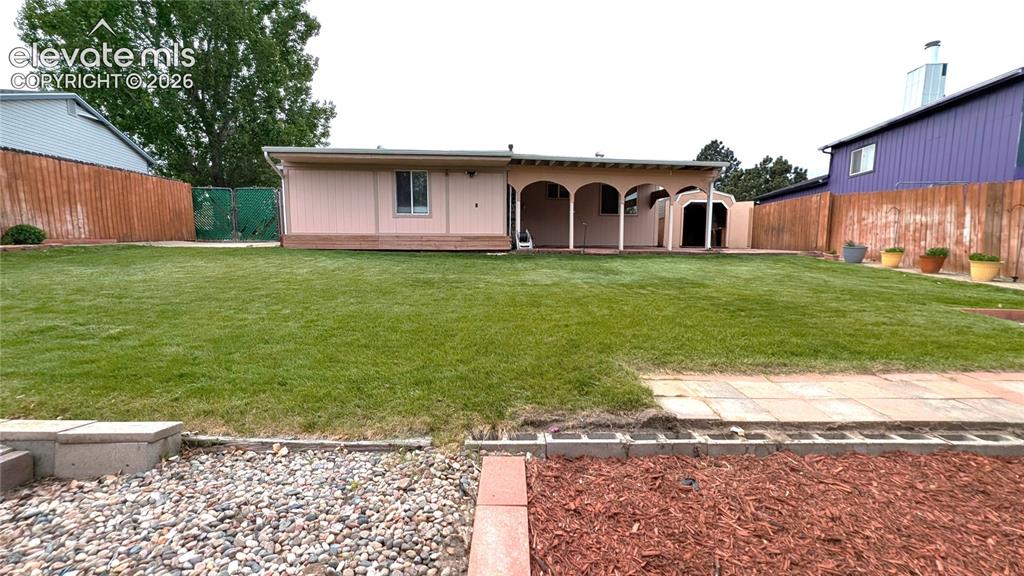 Image 13 of 16: Back of house, large covered patio, landscaped, beautiful grass, double-gat