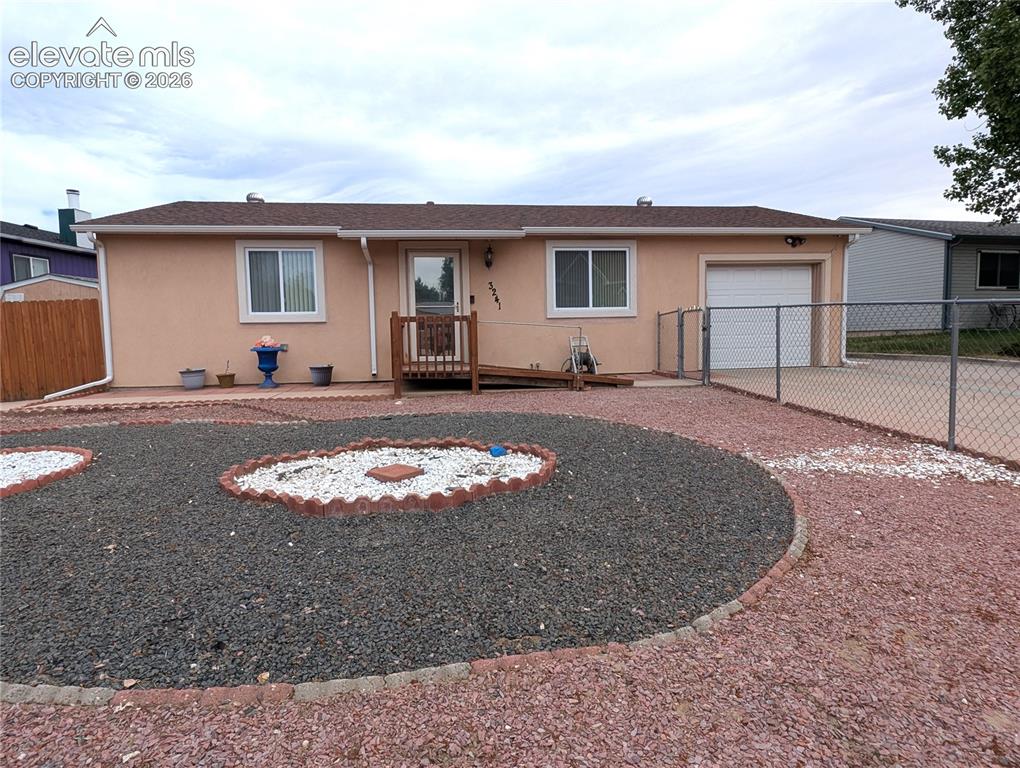 Image 16 of 16: Front of house, extra/RV parking, xeriscaped, handicap accessible ramp