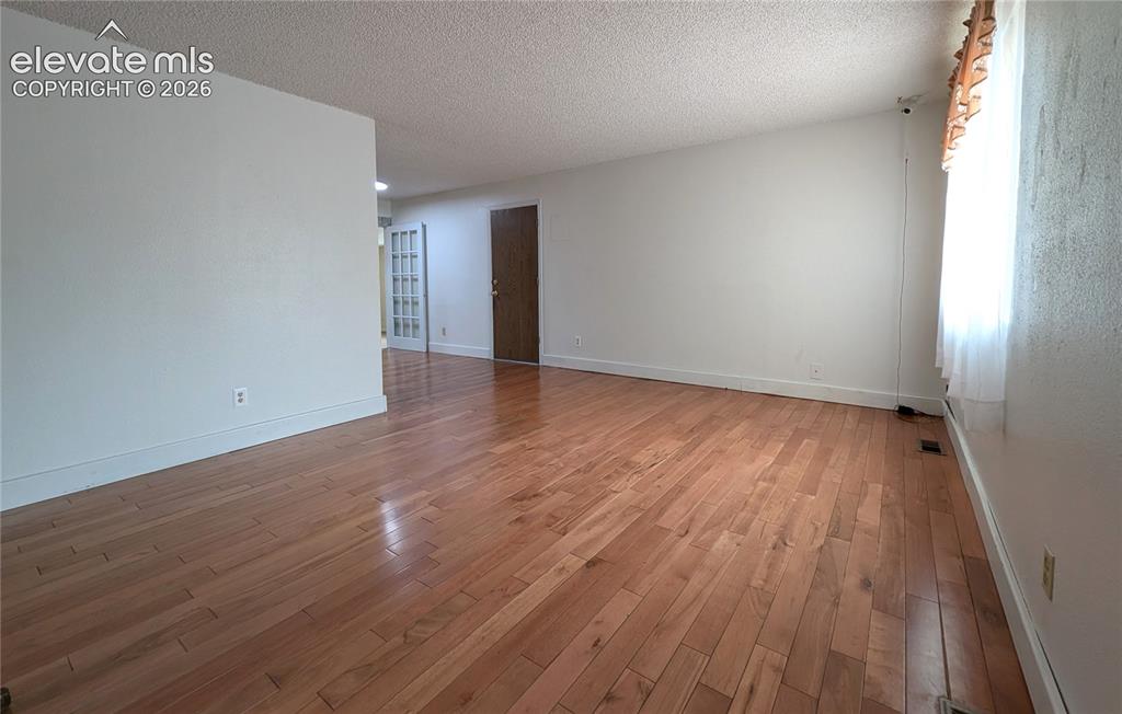 Image 3 of 16: Living room, view upon entry, door to garage