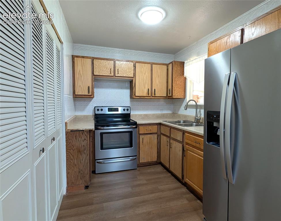 Image 5 of 16: Kitchen with newer ss fridge, electric stove/oven, gas connect, laundry acc