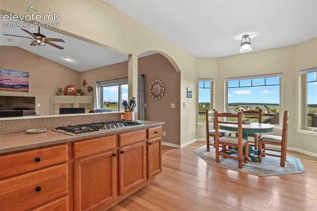 Image 11 of 45: Casual dining area adjacent to the kitchen with bay windows, hardwood floor