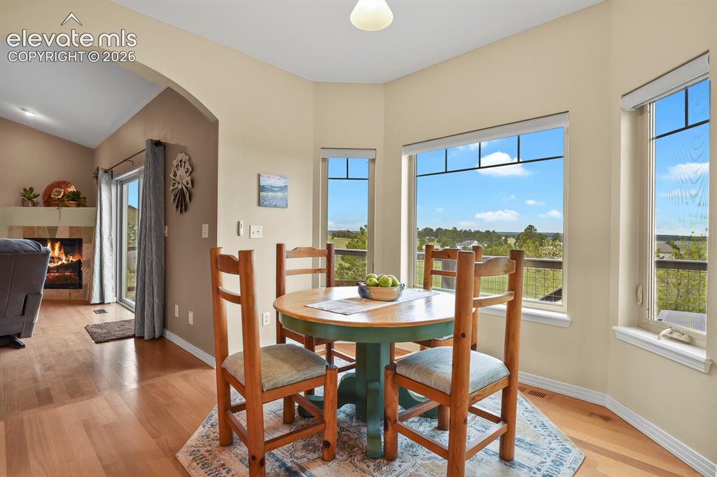 Image 12 of 45: Sunny breakfast nook surrounded by bay windows with peaceful pastoral views
