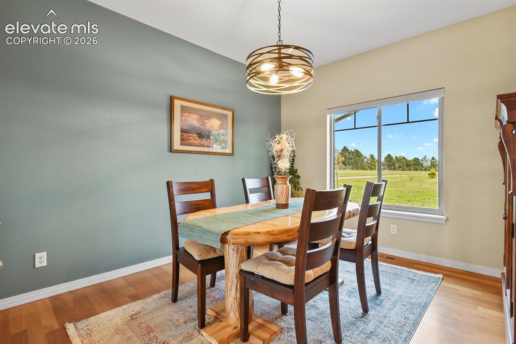 Image 13 of 45: Formal dining room with hardwood flooring, abundant natural light, and spac