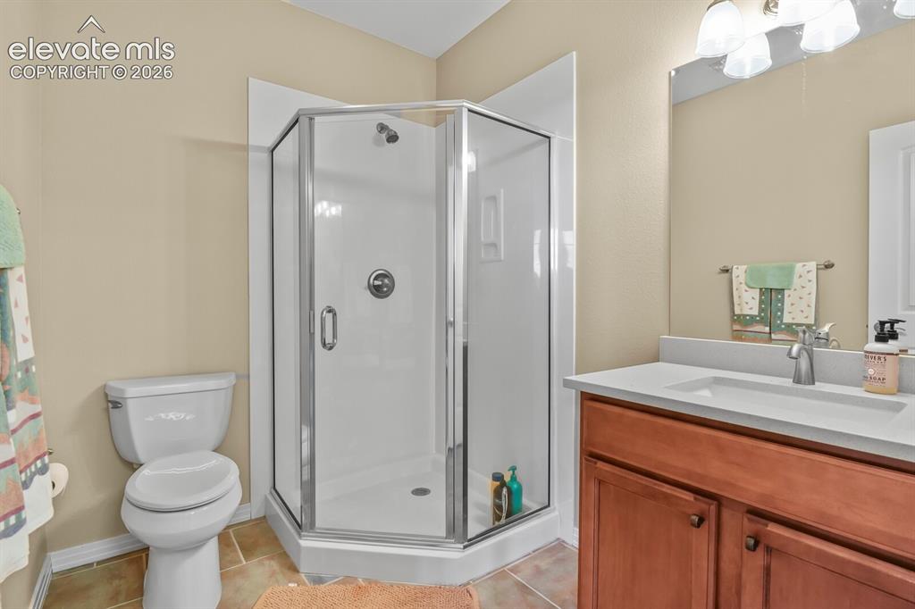 Image 31 of 45: Private ensuite 3/4 bath with walk-in shower serving the lower-level bedroo
