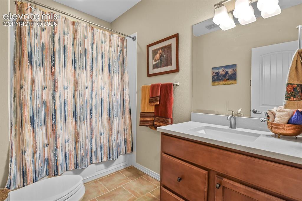 Image 33 of 45: Lower-level full bath with extended vanity, updated fixtures, and tub/showe