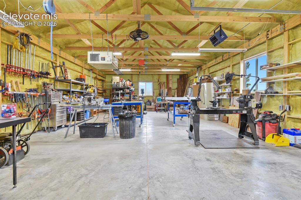 Image 38 of 45: Spacious workshop interior with high ceilings, abundant lighting, concrete 
