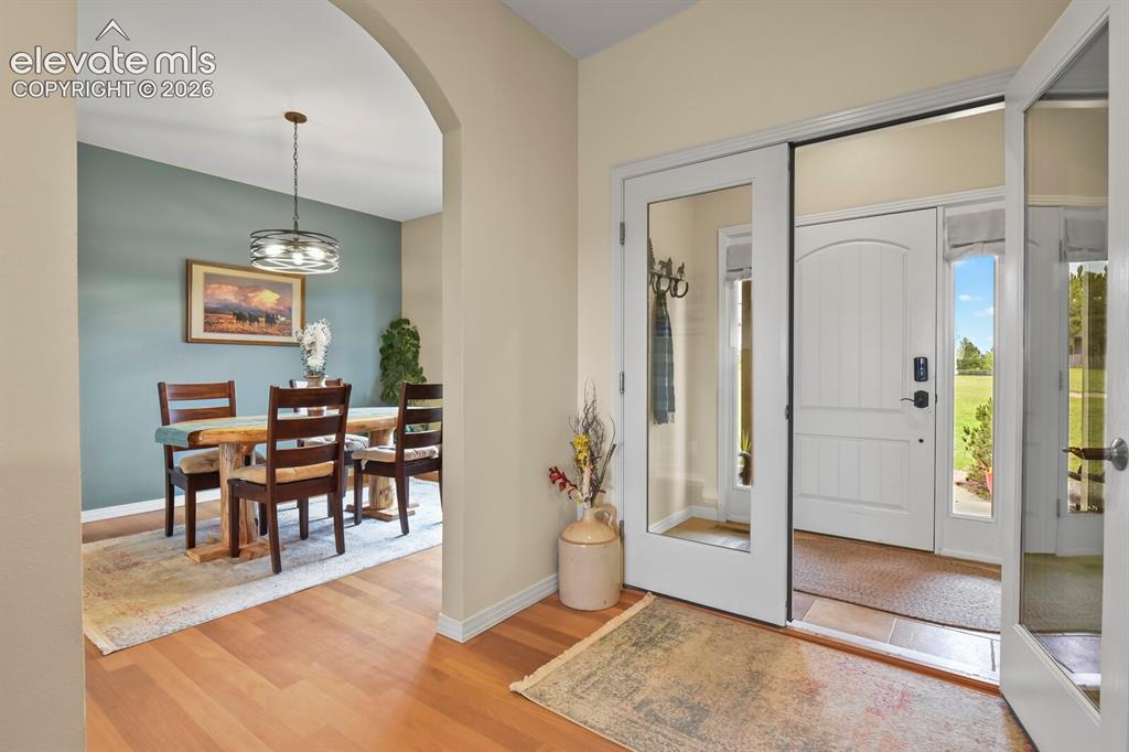 Image 6 of 45: Welcoming foyer with hardwood flooring and open sightlines into the formal 