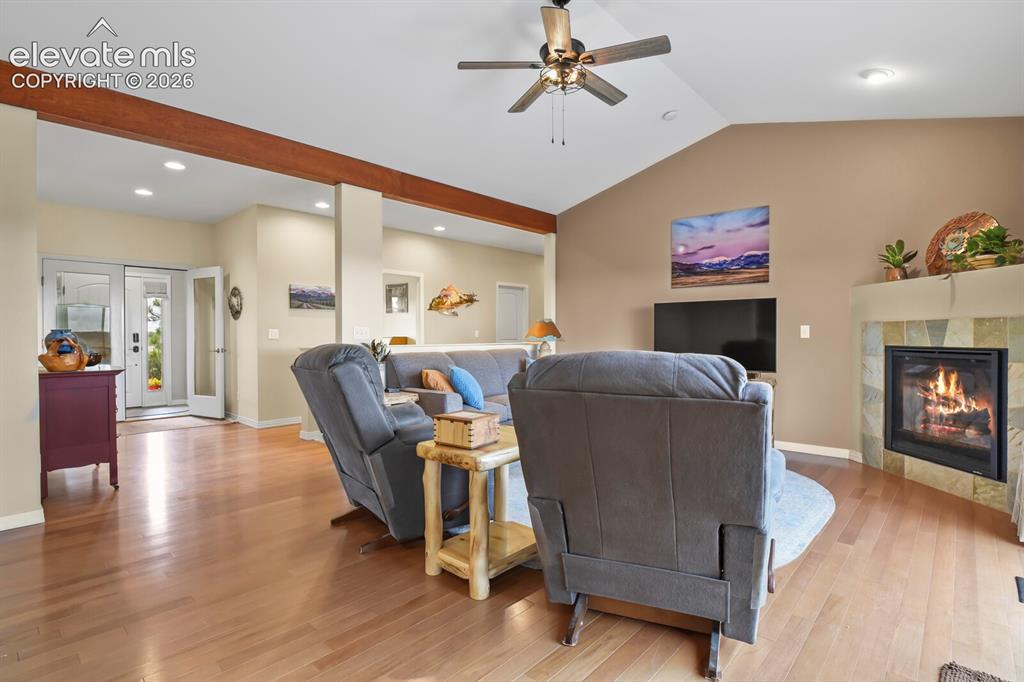 Image 8 of 45: Vaulted living room with hardwood flooring, gas fireplace, pastoral views, 