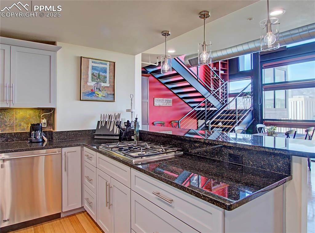 Image 14 of 32: Kitchen featuring stainless steel appliances, white cabinetry, a peninsula,
