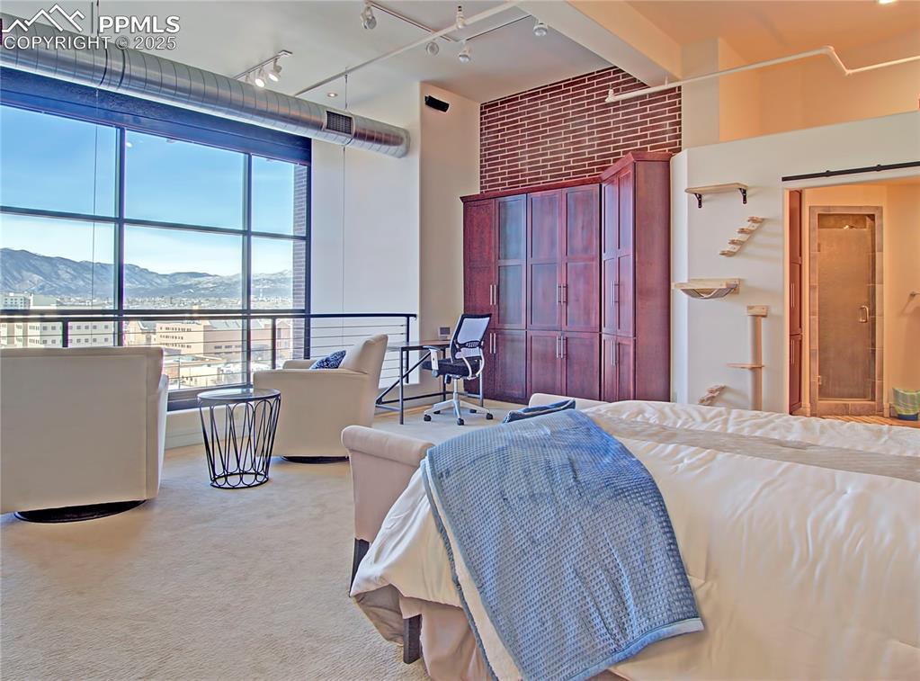 Image 19 of 32: Bedroom featuring a mountain view, an office area, light colored carpet, an