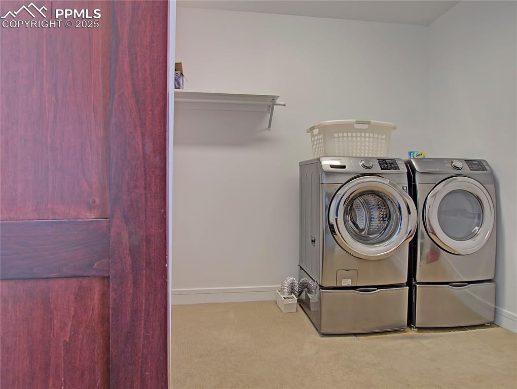Image 20 of 32: Washroom with carpet flooring and washer and dryer