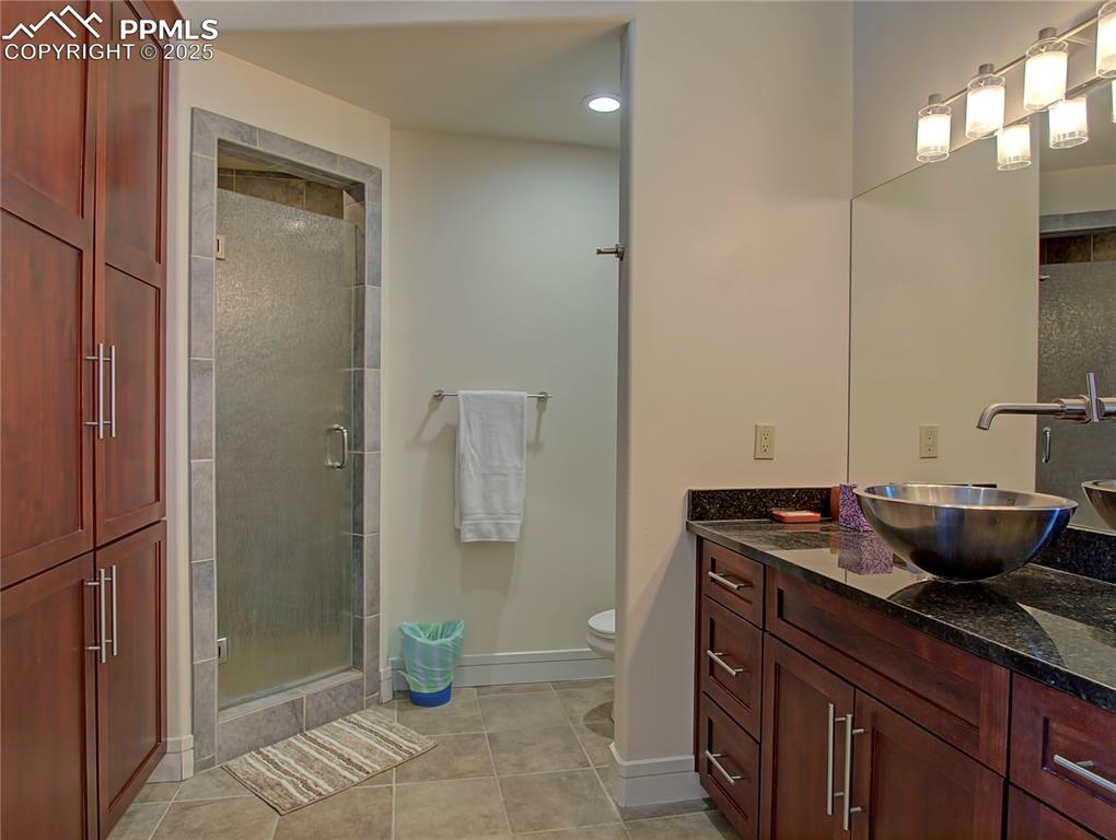 Image 23 of 32: Full bathroom featuring light tile patterned floors, vanity, and a shower s
